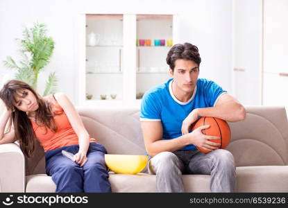 Man watching basketball with his wife