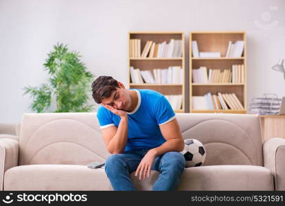 Man watching football at home sitting in couch