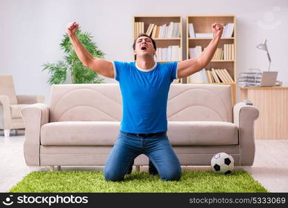 Man watching football at home sitting in couch