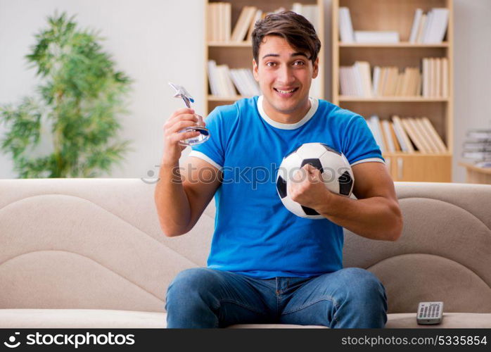 Man watching football at home sitting in couch