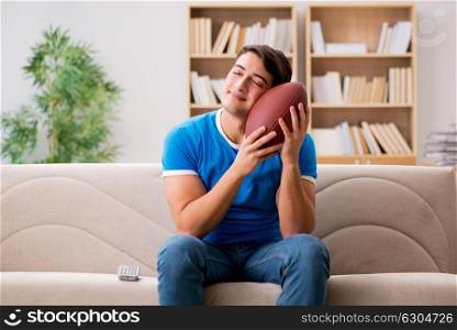 Man watching football at home sitting in couch