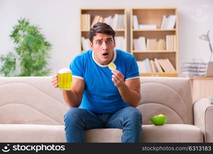 Man watching football at home sitting in couch