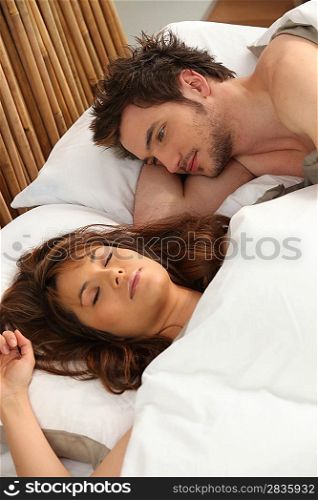 Man watching his girlfriend sleep
