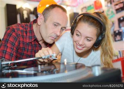 Man watching lady play vinyl record