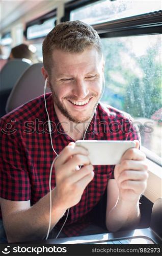 Man Watching Movie On Mobile Phone During Journey To Work
