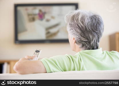 Man watching television using remote control