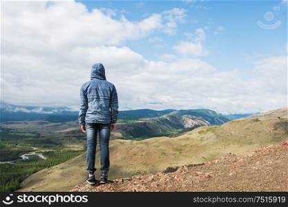 Man watching to glacier in Altai mountains. Resting in mountains or global warming concept. Relaxing man in Kurai steppe on North-Chui ridge