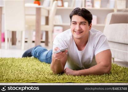 Man watching tv at home on floor