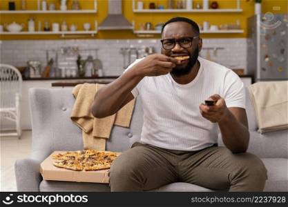 man watching tv eating pizza