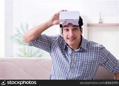Man watching virtual reality glasses at home