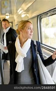 Man watching woman looking out the window train travel commuting