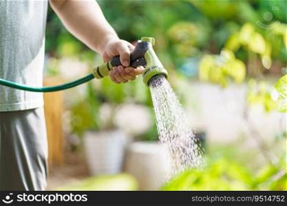 Man watering plants in his garden. Urban gardening watering fresh vegetables nature and plants care
