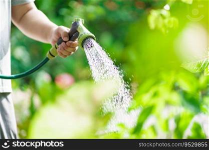 Man watering plants in his garden. Urban gardening watering fresh vegetables nature and plants care