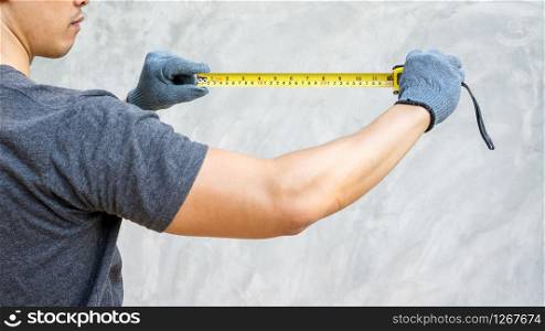 Man wear a glove and holding a measuring tape.
