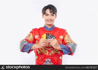 Man wear cheongsam carries several credit cards to go shopping during the Chinese New Year.