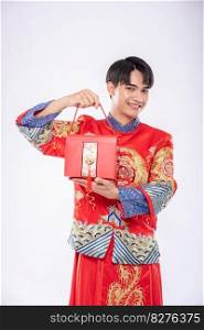 Man wear Cheongsam ready to give red bag to sister for surprising in traditional day