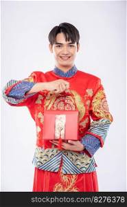 Man wear Cheongsam ready to give red bag to sister for surprising in traditional day