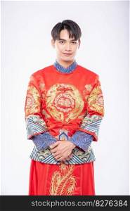 Man wear Cheongsam smile to welcome traveller shopping in chinese new year