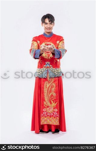 Man wear Cheongsam suit and black shoe smile  o give the gift money to his family