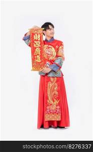 Man wear Cheongsam suit and wear black shoe give family the chinese greeting card for luck in chinese new year