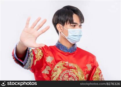 Man wearing a cheongsam and a mask shows that people who do not wear masks are unable to shop during the Lunar New Year.