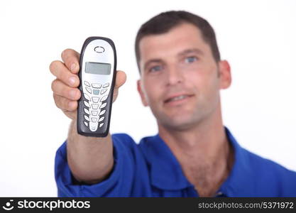 Man wearing blue jacket holding mobile telephone