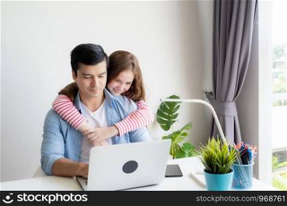 man wearing blue shirt as casual style and using laptop with daughter, working at home, technology aglie working home concept