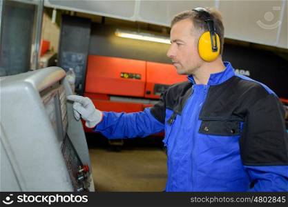 Man wearing ear protectors using machine