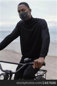 man wearing facial mask riding his bike