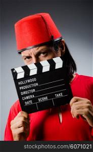 Man wearing fez hat with movie board