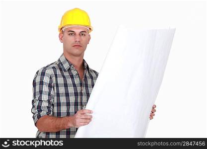 man wearing helmet and holding a blueprint