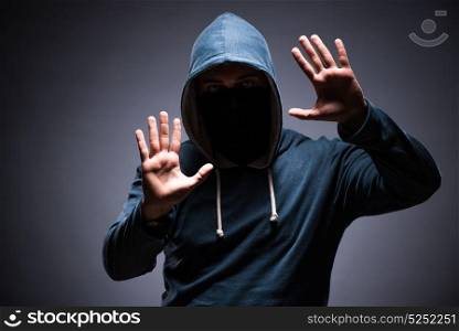 Man wearing hood in dark room