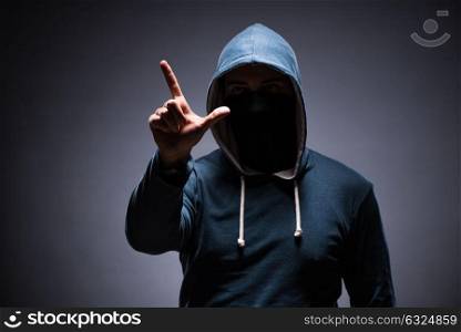 Man wearing hood in dark room
