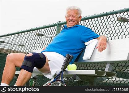 Man wearing knee band on tennis court