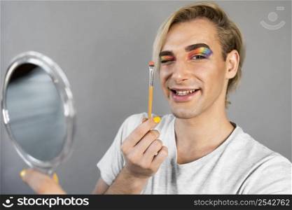 man wearing make up cosmetics holding brush