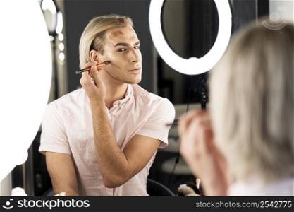 man wearing make up making his face contour