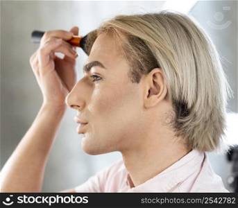man wearing make up using brush