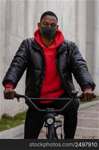 man wearing mask holding his bike 2