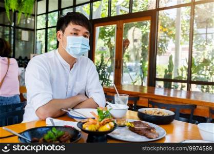 man wearing medical mask to protect coronavirus  covid-19  in the restaurant
