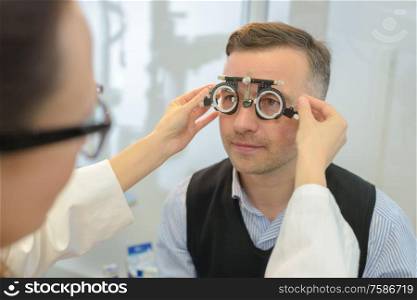 man wearing phoropter for eye test