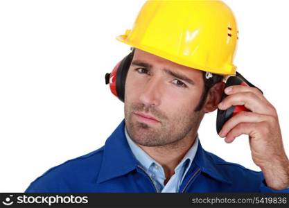 Man wearing safety earmuffs and helmet