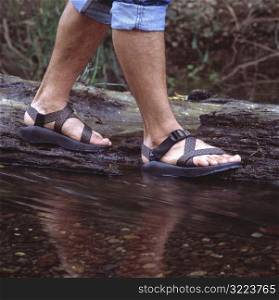 Man Wearing Sandals And Hiking Along The Riverside
