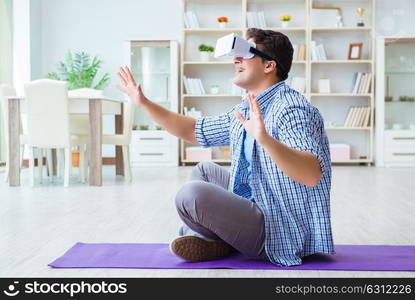 Man wearing virtual reality VR glasses doing sports at home. The man wearing virtual reality vr glasses doing sports at home