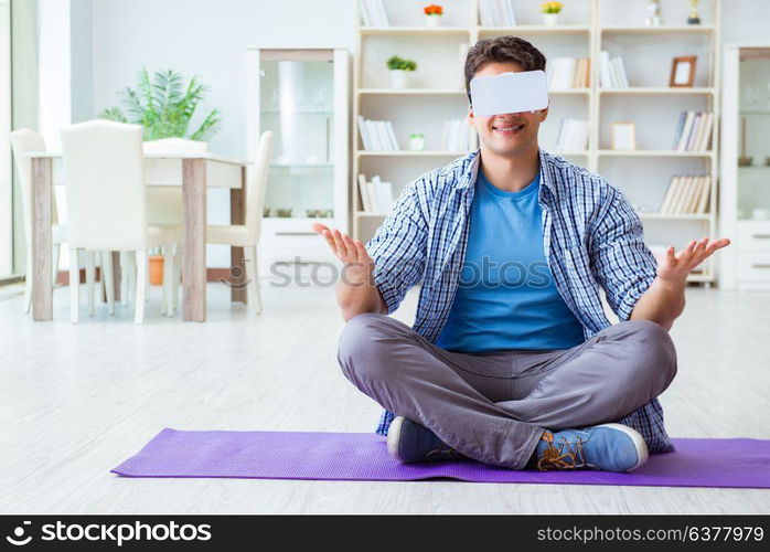 Man wearing virtual reality VR glasses meditating on floor at home. Man wearing virtual reality VR glasses meditating on floor at ho