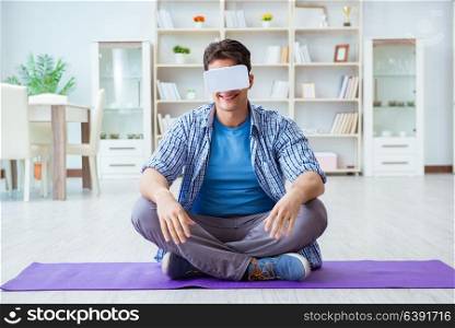 Man wearing virtual reality VR glasses meditating on floor at home. Man wearing virtual reality VR glasses meditating on floor at ho