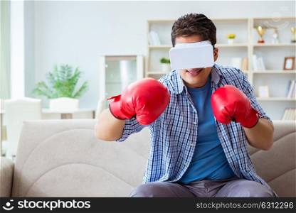 Man wearing virtual reality VR glasses playing boxing game. The man wearing virtual reality vr glasses playing boxing game