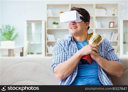 Man wearing virtual reality VR glasses receiving prize cup award. The man wearing virtual reality vr glasses receiving prize cup award