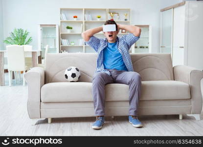 Man wearing virtual reality VR glasses watching soccer football. The man wearing virtual reality vr glasses watching soccer football