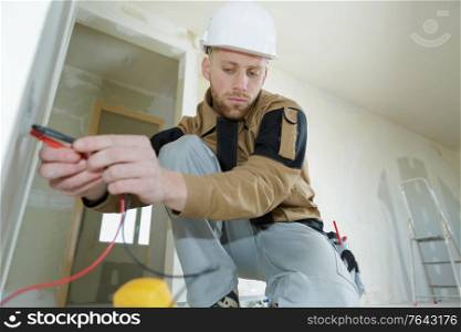 man wearing working on electrical wall socke
