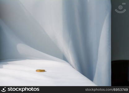 Man wedding ring on white cloth background.